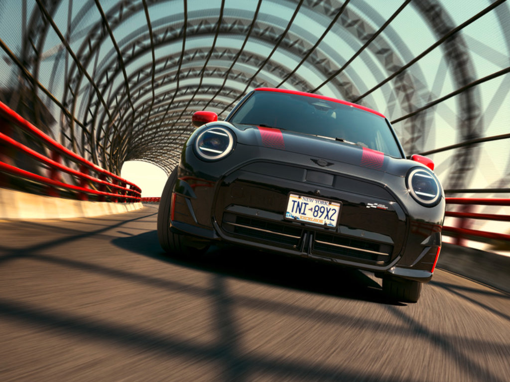 A MINI JCW drives over a gated bridge that looks like a tunnel.