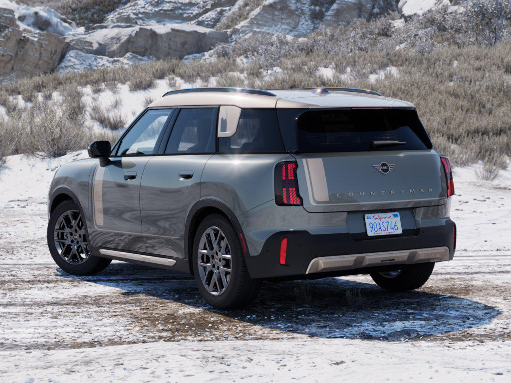 A back angled view of a MINI Countryman sitting in front of a snowy hillside.