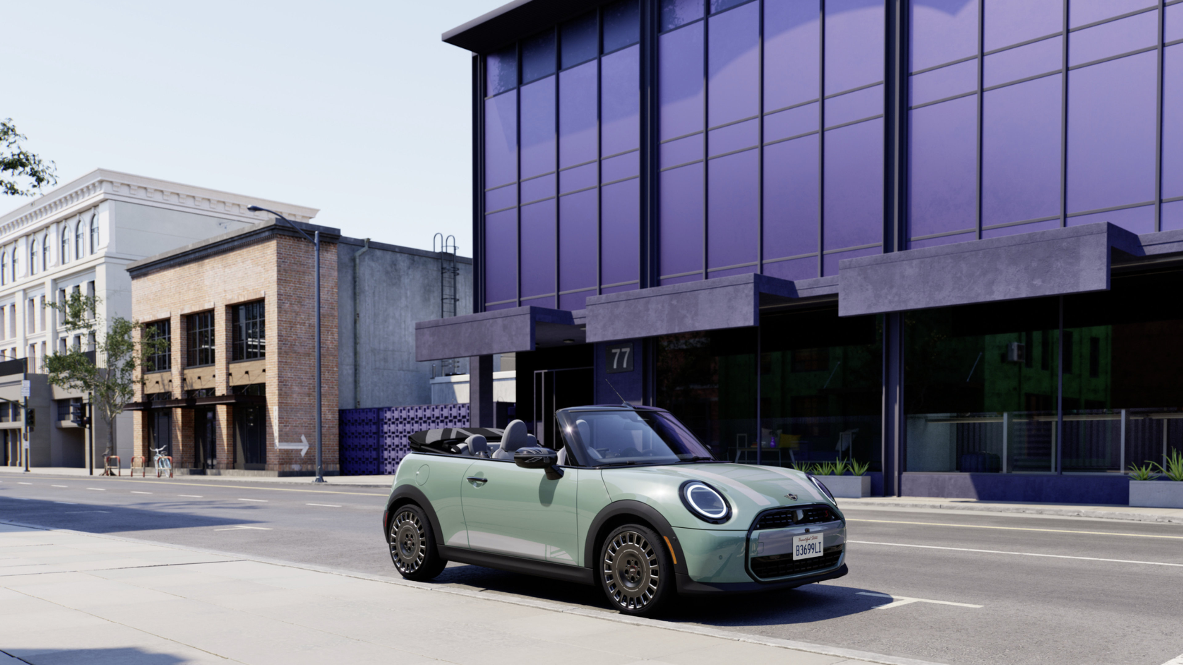A green MINI convertible with the top down is parked in front of a large purple building